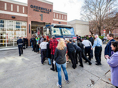 Community pushing in fire truck