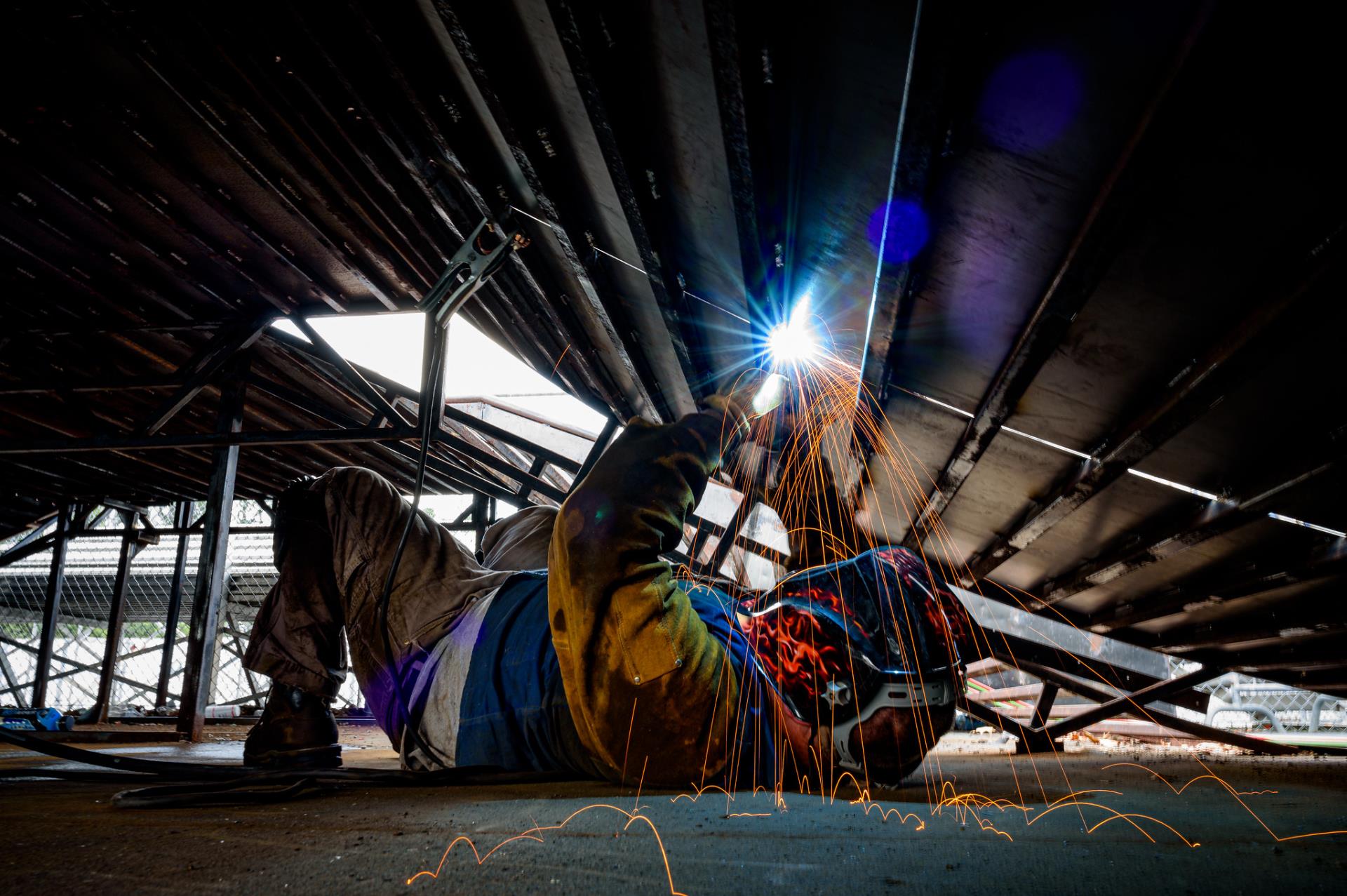 Welder repairing skate park ramp