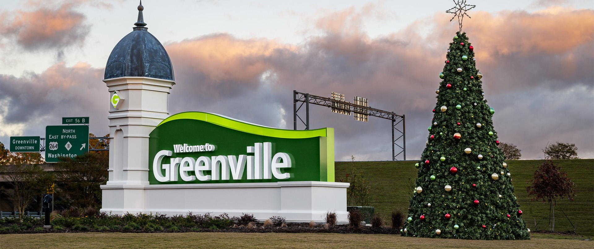 Image of the City welcome sign at sunset with the Christmas tree beside it