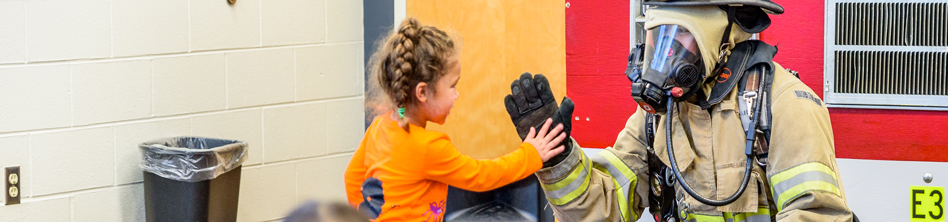 Firefighter high-fiving a kid